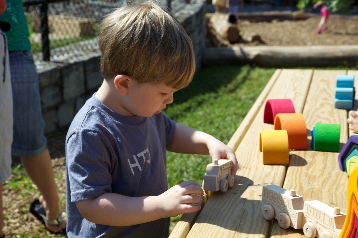 A young child playing with wood toys